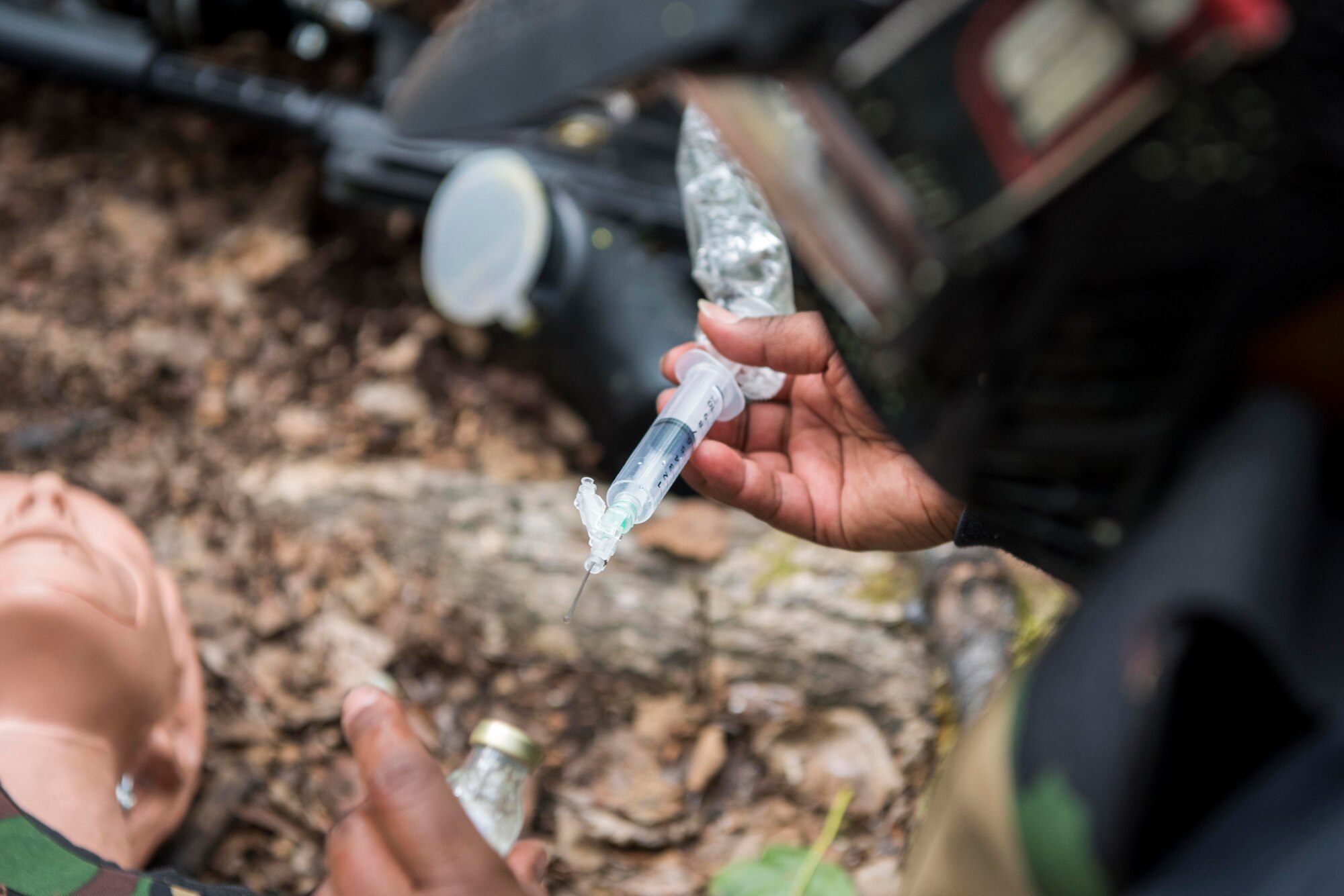 U.S. Air Force Staff Sgt. CaTeah Bryant, an aerospace medical services Airman assigned to the 673d Inpatient Operations Squadron, prepares a trenexamic acid dose during the practical application of the Tactical Combat Casualty Care course at Warrior Extreme Paintball course at Joint Base Elmendorf-Richardson, Alaska, July 13, 2018. Trenexamic acid is a medication used to treat or prevent major blood loss from trauma.