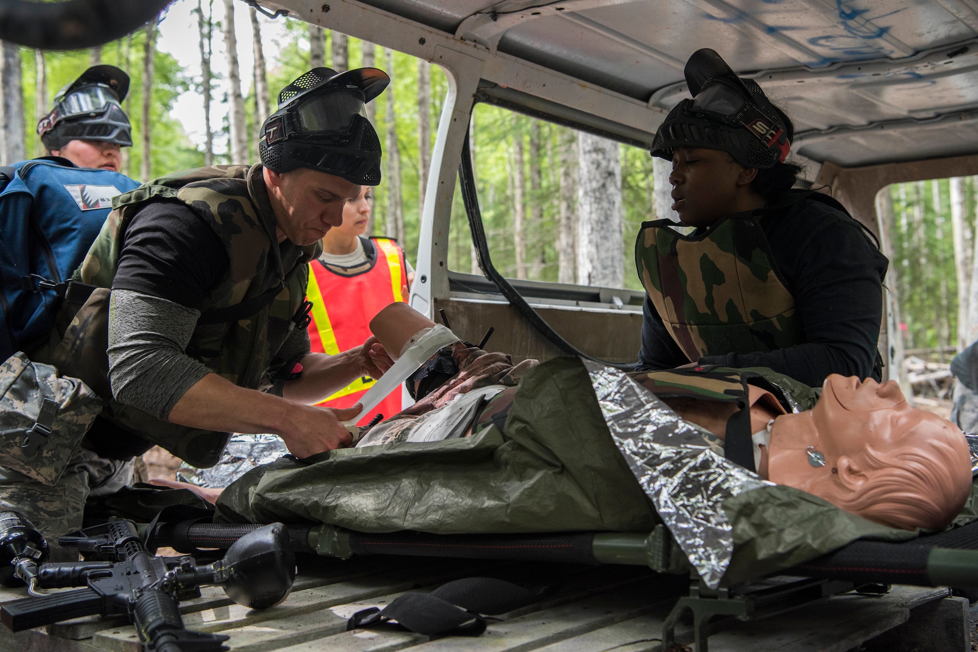 Personnel from the 673d Medical Group cover the wounds of an injured “patient” during the practical application of the Tactical Combat Casualty Care course at the Warrior Extreme Paintball course at Joint Base Elmendorf-Richardson, Alaska, July 13, 2018. The course is an opportunity for every student to provide care under fire, perform tactical field care on those who are injured and execute a tactical evacuation.