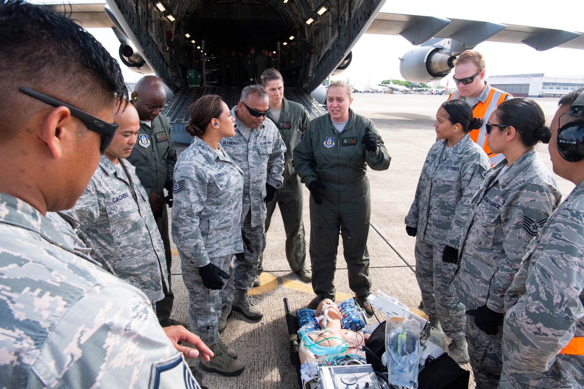 U.S. Air Force Maj. Venus Victorino, a member of the Critical Care Air Transport Team with the 943rd Aerospace Medicine Squadron, discusses critical-care patient transportation with 624th Aeromedical Staging Squadron personnel at U.S. Coast Guard Air Station Barbers Point, Hawaii, July 10, 2018, during Pacific Lifeline 2018. Pacific Lifeline 2018 is a statewide medical exercise in Hawaii conducted as part of a larger 2018 Rim of the Pacific Exercise.