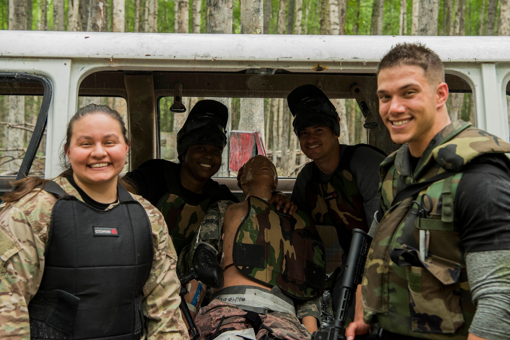 Personnel from the 673d Medical Group pose for a photo during the practical application of the Tactical Combat Casualty Care course at the Warrior Extreme Paintball course at Joint Base Elmendorf-Richardson, Alaska, July 13, 2018. The course is an opportunity for every student to provide care under fire, perform tactical field care on those who are injured and execute a tactical evacuation.