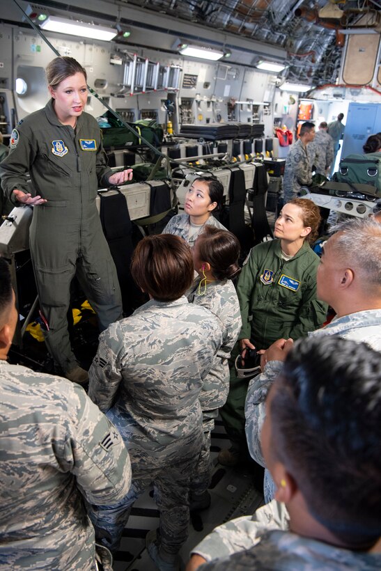 U.S. Air Force Capt. Jennifer Riportella, a flight nurse with the 446th Aeromedical Evacuation Squadron, discusses patient transport equipment used aboard a U.S. Air Force C-17 Globemaster III aircraft with 624th Aeromedical Staging Squadron personnel at U.S. Coast Guard Air Station Barbers Point, Hawaii, July 10, 2018, during Pacific Lifeline 2018.