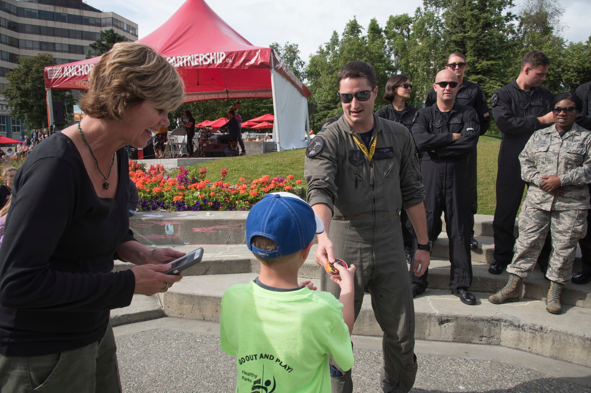 Alaskan natives, Bonnie Luther, left, and her grandson, Maddox Luther, center, receive a Pacific Air Forces’ F-16 Demonstration Team sticker from U.S. Air Force Capt. Jake Impellizzeri, the PACAF F-16 Demonstration Team pilot, during a meet-and-greet session in Anchorage, Alaska, June 29, 2018. The team performed at the Arctic Thunder 2018 air show and showcased the F-16 Fighting Falcon’s capabilities. During their trip, the team engaged with the community to strengthen bonds between the Air Force and the local area. (U.S. Air Force photo by Senior Airman Sadie Colbert)