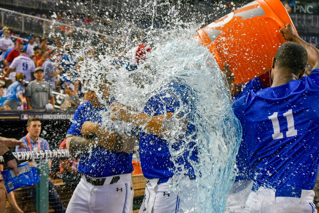 Airmen dump a cooler of water on someone.