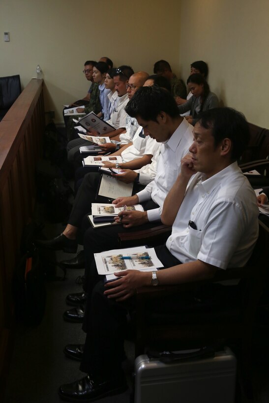 KADENA AIR BASE, OKINAWA, Japan – Representatives from local government agencies listen to trial procedures and read through information packets June 29 during a mock trial on Kadena Air Base, Okinawa, Japan.