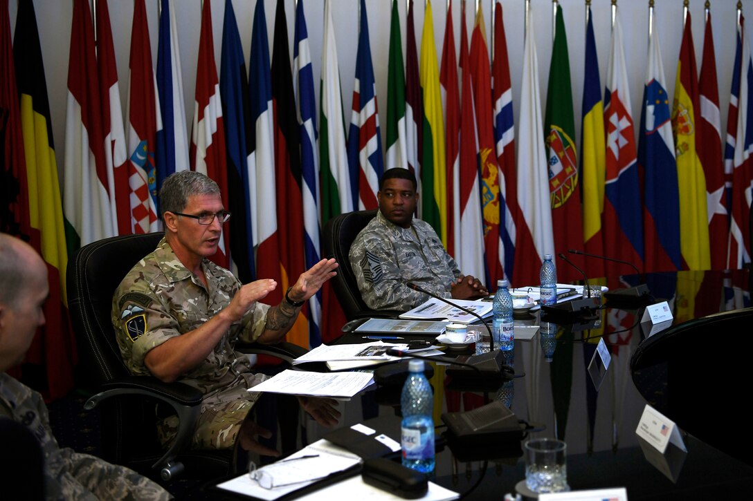 Royal Air Force Chief Warrant Officer Jake Alpert, Allied Air Command command senior enlisted leader and U.S. Air Force Chief Master Sgt. Phillip L. Easton, U.S. Air Forces in Europe and Air Forces in Africa command chief, converse during the Romanian air force’s International SEL Visit at Bucharest, Romania, July 10, 2018.
