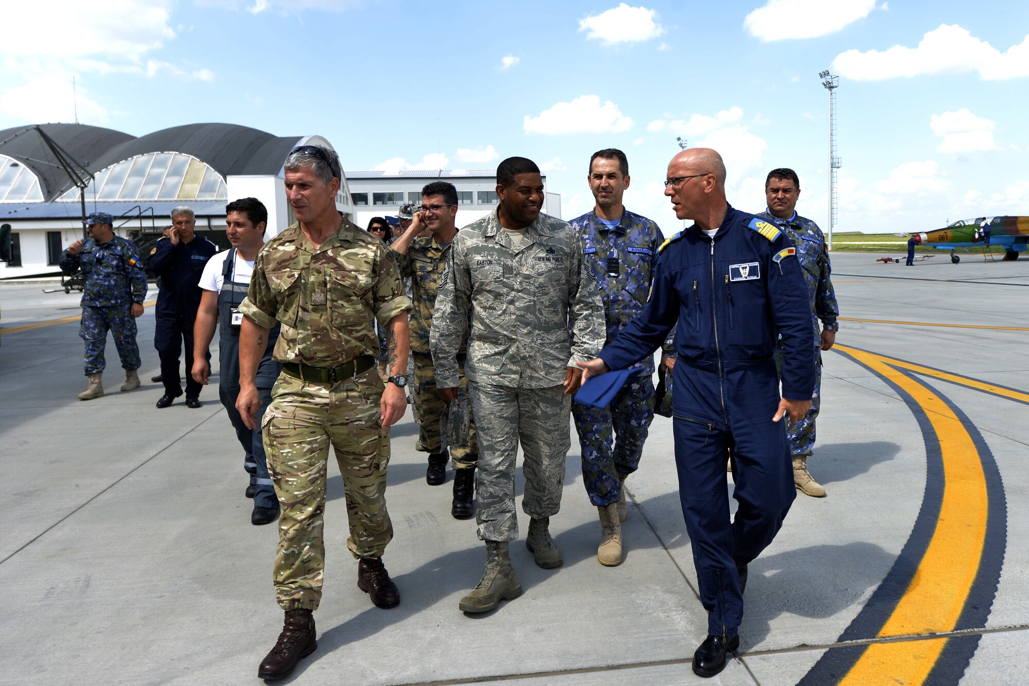 Romanian air force’s International Senior Enlisted Leader Visit attendees walk the flight line at Borcea Air Force Base, Romania, July 11, 2018.