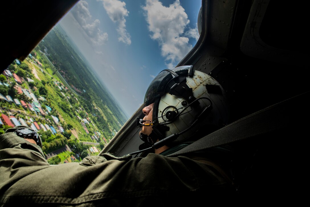 U.S. Marine Cpl. Miguel Barajas, a CH-53E Super Stallion helicopter crew chief with Special Purpose Marine Air-Ground Task Force - Southern Command, scans a small town during a flight near Flores, Guatemala, July 15, 2018. The Marines and sailors of SPMAGTF-SC are conducting security cooperation training and engineering projects alongside partner nation military forces in Central and South America. The unit is also on standby to provide humanitarian assistance and disaster relief in the event of a hurricane or other emergency in the region.