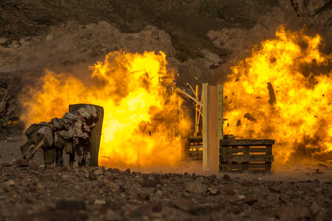 U.S. Marines assigned to Battalion Landing Team, 2nd Battalion, 6th Marine Regiment, 26th Marine Expeditionary Unit, take cover from demolitions during sustainment training at Camp Titin, Jordan, July 8, 2018. Iwo Jima is the flagship for the Iwo Jima Amphibious Ready Group and, with the embarked 26th Marine Expeditionary Unit, is deployed to the U.S. 5th Fleet area of operations in support of naval operations to ensure maritime stability and security in the Central region, connecting the Mediterranean and the Pacific through the western Indian Ocean and three strategic choke points.