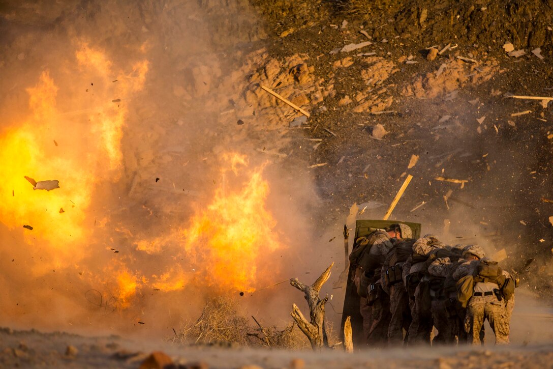 U.S. Marines assigned to Combat Logistics Battalion-26, 26th Marine Expeditionary Unit, take cover from demolitions during sustainment training at Camp Titin, Jordan, July 8, 2018. Iwo Jima is the flagship for the Iwo Jima Amphibious Ready Group and, with the embarked 26th Marine Expeditionary Unit, is deployed to the U.S. 5th Fleet area of operations in support of naval operations to ensure maritime stability and security in the Central region, connecting the Mediterranean and the Pacific through the western Indian Ocean and three strategic choke points.