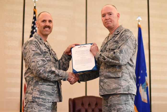 Col. Todd M. Vician, left, Air Force Public Affairs Agency commander, awards the Meritorious Service Medal to Lt. Col. Christopher A. Anderson, outgoing commander of the 1st Combat Camera Squadron, during a change of command ceremony July 17, 2018, at Joint Base Charleston, S.C