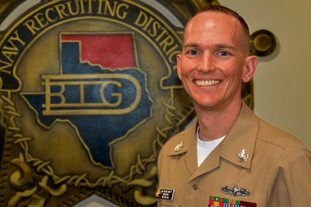 A Navy recruiter poses for a picture.