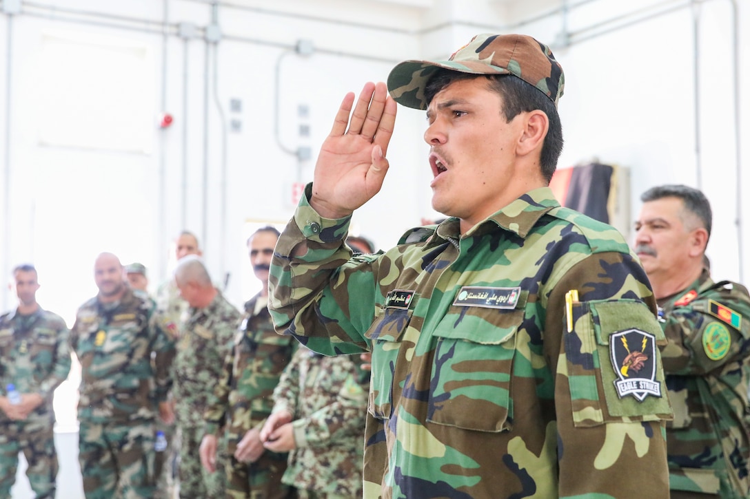 An Afghan soldier salutes at a graduation.