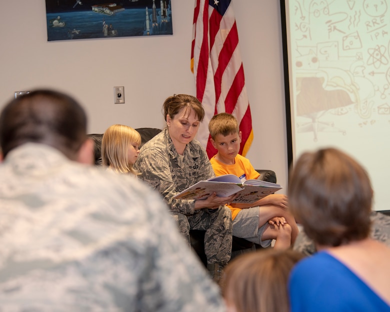 Col. Jennifer Grant, commander of the 50th Space Wing, reads "Ada Twist, Scientist" to families attending Tell Me A Story: Making Connections and Finding Support through Literature in the event center at Schriever Air Force Base, Colorado, July 12, 2018. The Military Child Education Coalition believes stories have the capacity to open families to discussion on difficult topics such as: family separation, deployment, moving, grief, and crisis. (U.S. Air Force photo by Staff Sgt. Matthew Coleman-Foster)