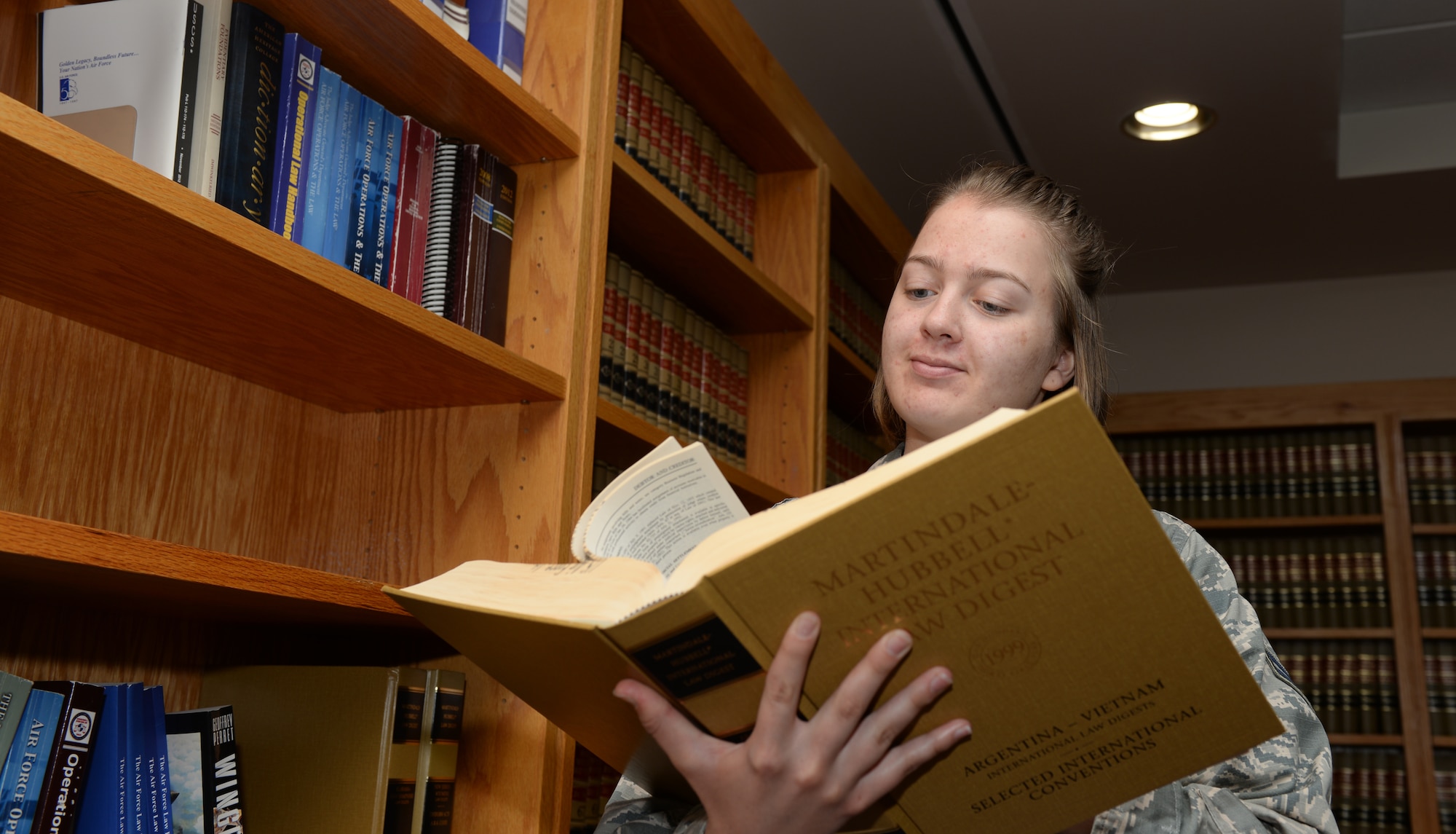 Airman 1st Class Mary Walsh, a 28th Bomb Wing general law paralegal, reads a book on prior military court cases at Ellsworth Air Force Base, S.D., July 17, 2018. Most papers and documents pertaining to legal trials are found online for legal personnel, and the 28th Bomb Wing legal office has a library with over 300 volumes of different court proceedings. (U.S. Air Force photo by Airman 1st Class Nicolas Z. Erwin)