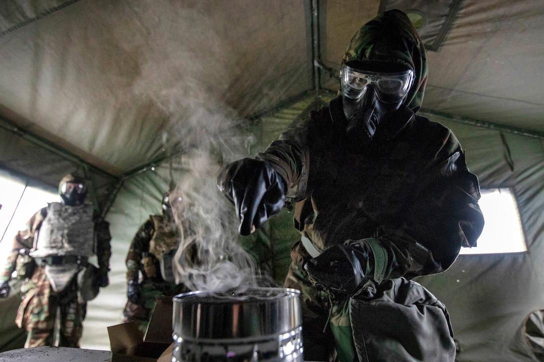 An airman trains in a gas mask confidence chamber.