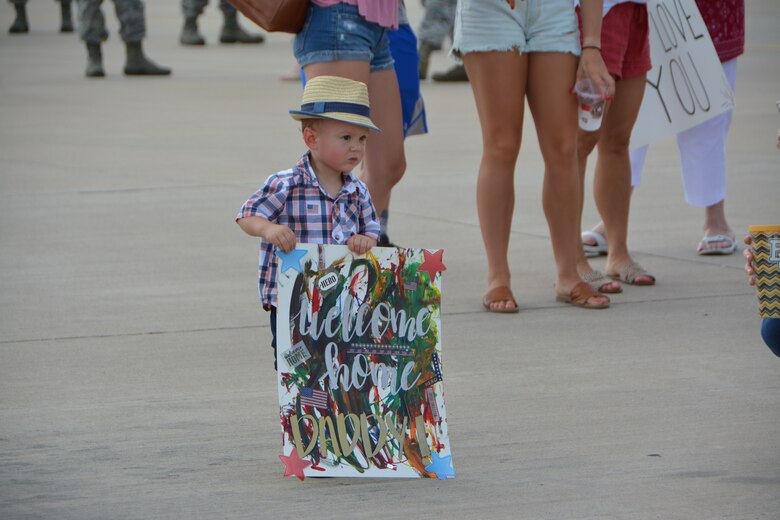 A child holds a welcome home sign made for his father July 5, 2018, at Tinker Air Force Base, Okla. More than 100 Reserve Citizen Airmen from the 507th Air Refueling Wing at Tinker AFB deployed to Incirlik Air Base, Turkey, in support of air operations. (U.S. Air Force photo by Tech. Sgt. Samantha Mathison)