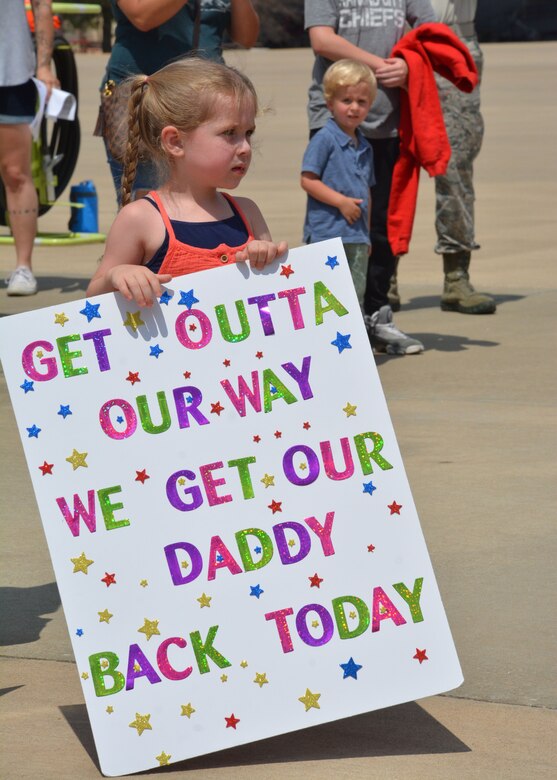 A child holds a handmade poster while waiting for her father to return from deployment at Tinker Air Force Base, Okla., July 7, 2018. More than 100 Reserve Citizen Airmen from the 507th ARW at Tinker AFB deployed to Incirlik Air Base, Turkey, in support of air operations. (U.S. Air Force photo by Master Sgt. Grady Epperly)