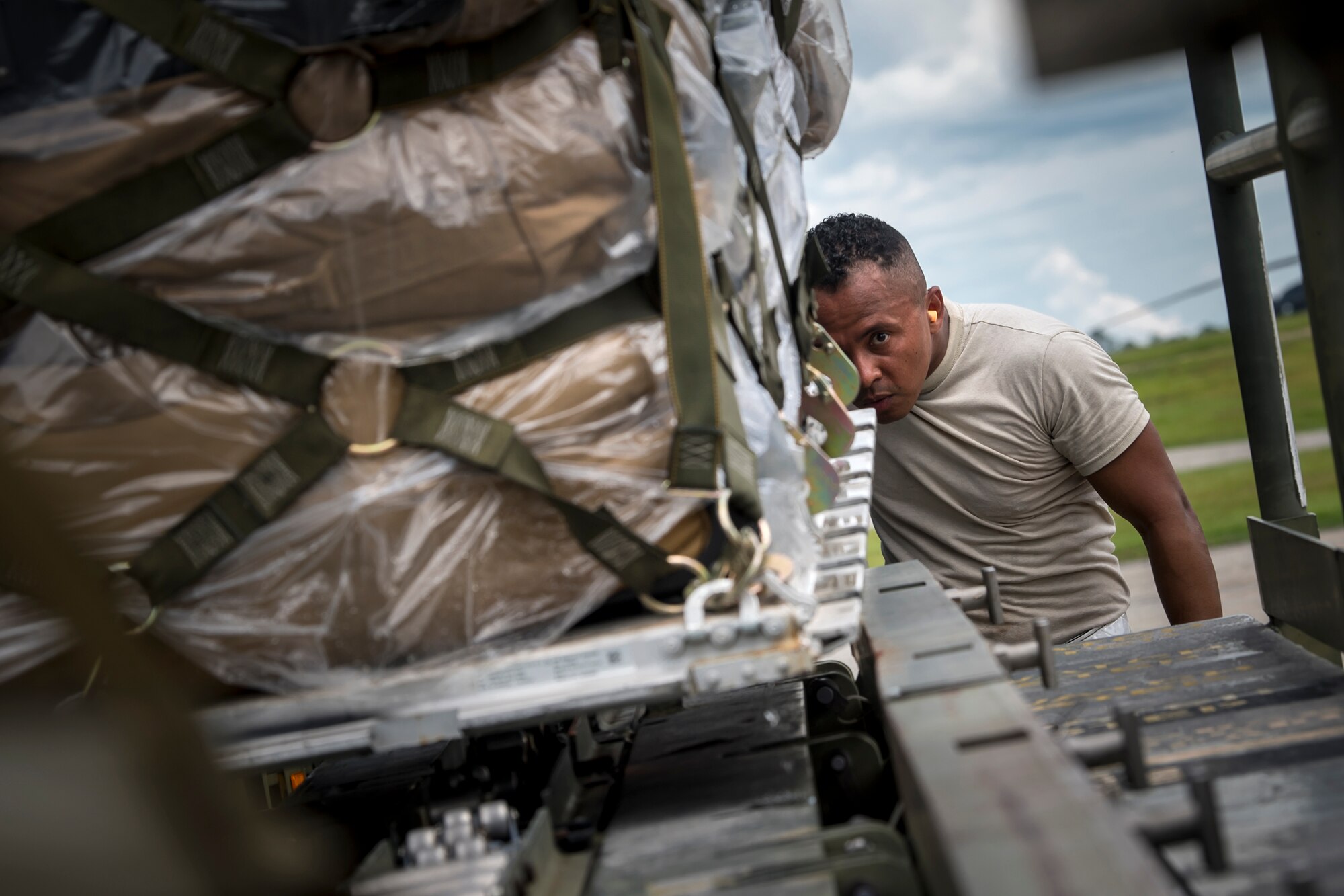 Staff Sgt. Mauricio Castaneda, 23d Logistics Readiness Squadron assistant NCO in charge of air terminal operations, inspects the alignment of cargo on a transport belt, July 5, 2018, at Moody Air Force Base, Ga. Airmen loaded approximately 68,000 pounds of cargo onto a C-17 Globemaster III to aid the 75th Fighter Squadron (FS) prior to a deployment. The 75th FS and supporting units recently deployed to an undisclosed location in support of Operation Spartan Shield. (U.S. Air Force photo by Airman 1st Class Eugene Oliver)