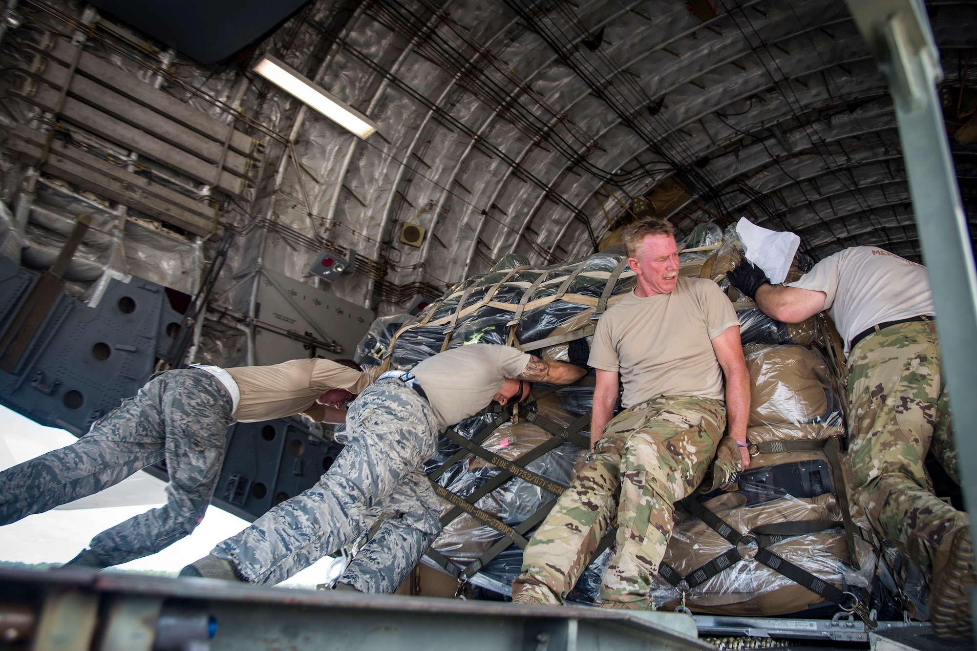 Airmen push cargo up the ramp of a C-17 Globemaster III, July 5, 2018, at Moody Air Force Base, Ga. Airmen loaded approximately 68,000 pounds of cargo onto a C-17 Globemaster III to aid the 75th Fighter Squadron (FS) prior to a deployment. The 75th FS and supporting units recently deployed to an undisclosed location in support of Operation Spartan Shield. (U.S. Air Force photo by Airman 1st Class Eugene Oliver)