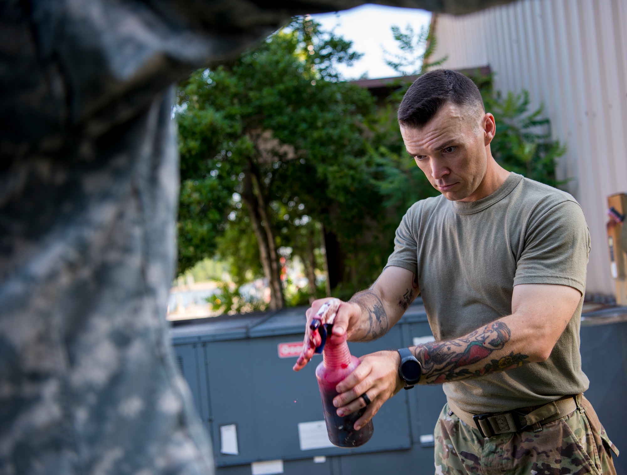 U.S. Army Staff Sgt. Chase Johnson, U.S. Army Medical Activity operations NCO, applies moulage to a volunteer prior to an aircraft crash exercise at Joint Base Langley-Eustis, Virginia, July 17, 2018.