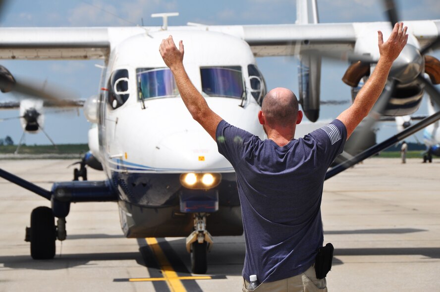 A maintainer signals a C-145 Skytruck aircrew as they taxi into their designated parking spot July 11, 2018 at Duke Field, Fla.
