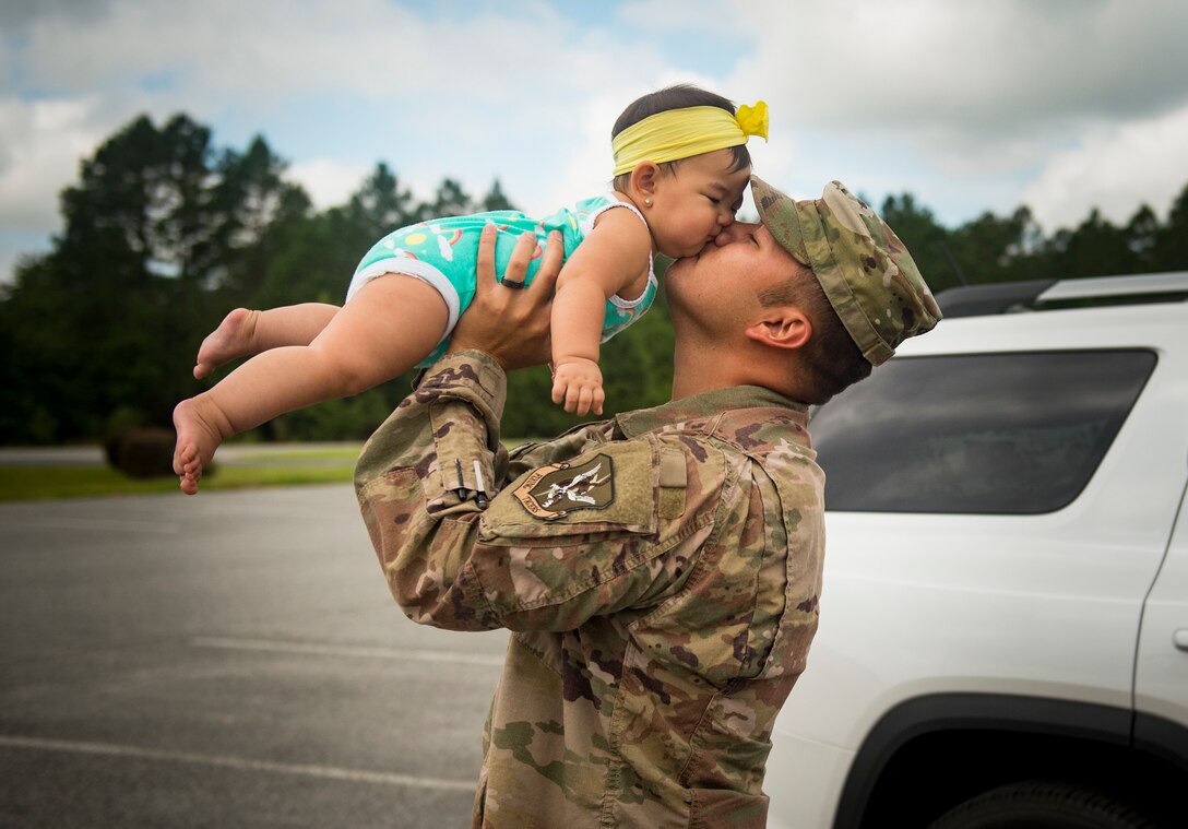 Tech. Sgt. Ramon Salas, 23d Aircraft Maintenance Squadron electrical and environmental craftsman, kisses his daughter Luna, July 9, 2018, at Moody Air Force Base, Ga. Airmen from the 75th Fighter Squadron (FS) and supporting units deployed to an undisclosed location in support of Operation Spartan Shield. (U.S. Air Force photo by Staff Sgt. Ceaira Tinsley)