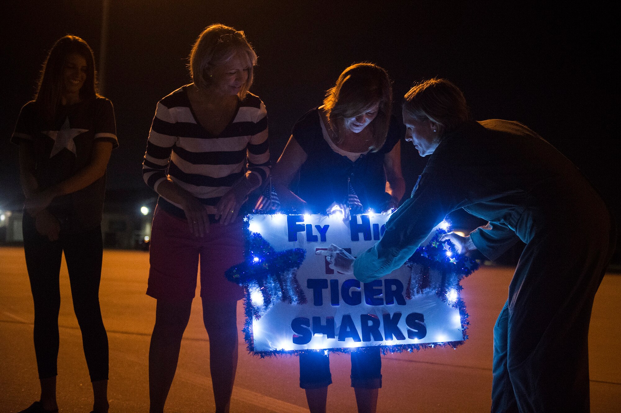 Col. Jennifer Short, 23d Wing commander, helps a family adjust their sign July 9, 2018, at Moody Air Force Base, Ga. Airmen from the 75th FS and supporting units deployed to an undisclosed location in support of Operation Spartan Shield. (U.S. Air Force photo by Staff Sgt. Ceaira Tinsley)