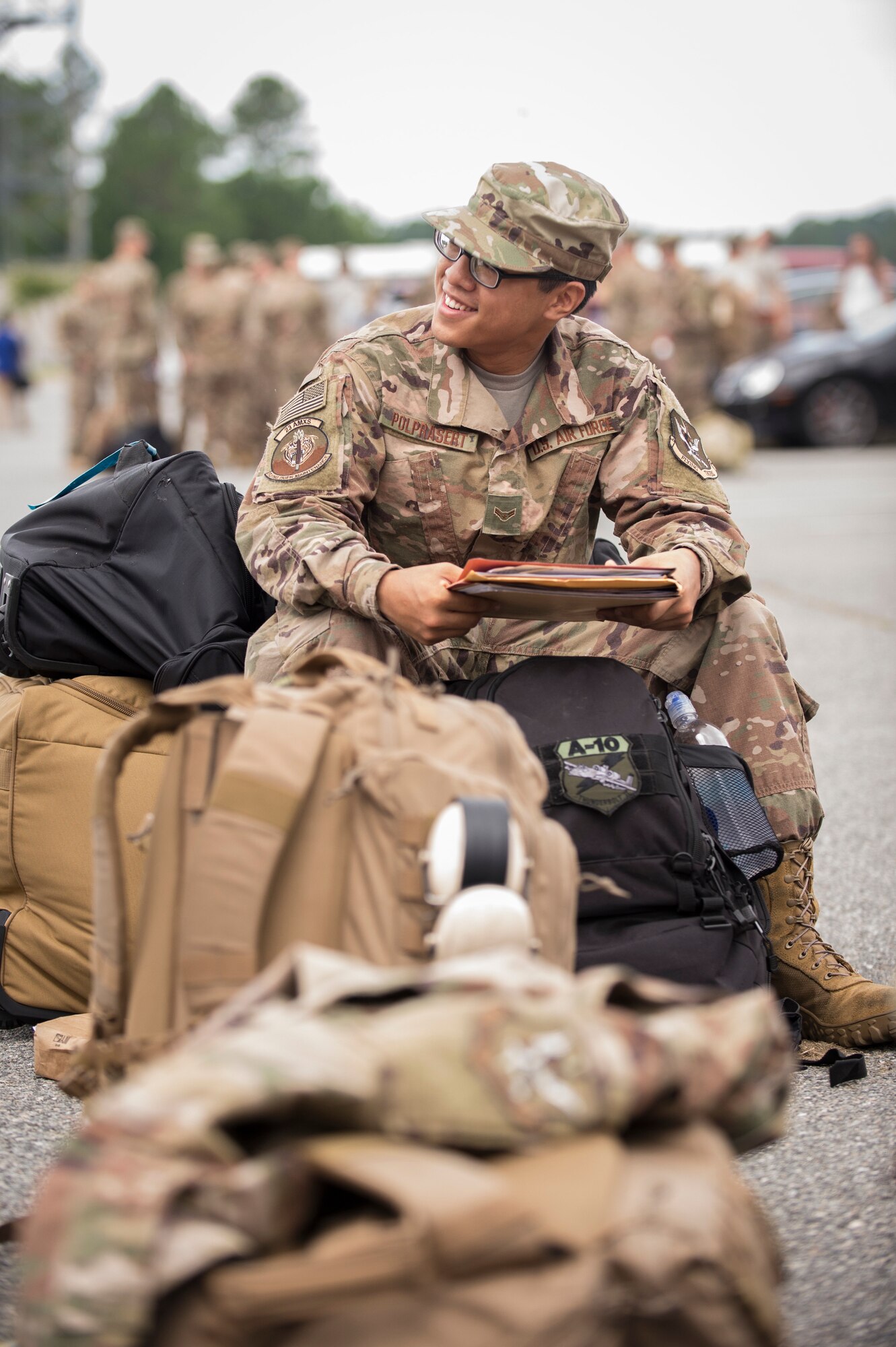 Airman 1st Class Michael Polprasert, 23d Aircraft Maintenance Squadron, sits on his luggage prior to a deployment, July 8, 2018, at Moody Air Force Base, Ga. Airmen from the 75th Fighter Squadron (FS) and supporting units deployed to an undisclosed location in support of Operation Spartan Shield. (U.S. Air Force photo by Andrea Jenkins)