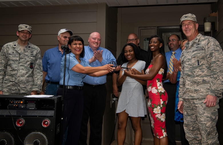 The ceremonial key is presented by Dorothy Molina, community manager for Balfour Beatty Communities, to the family moving into the final renovated home at Chavez West base housing on Cannon Air Force Base, N.M., July 17, 2018. This momentous occasion signified the ending of a four-year, $170 million housing project. (U.S. Air Force Photo by Staff Sgt. Charles Dickens