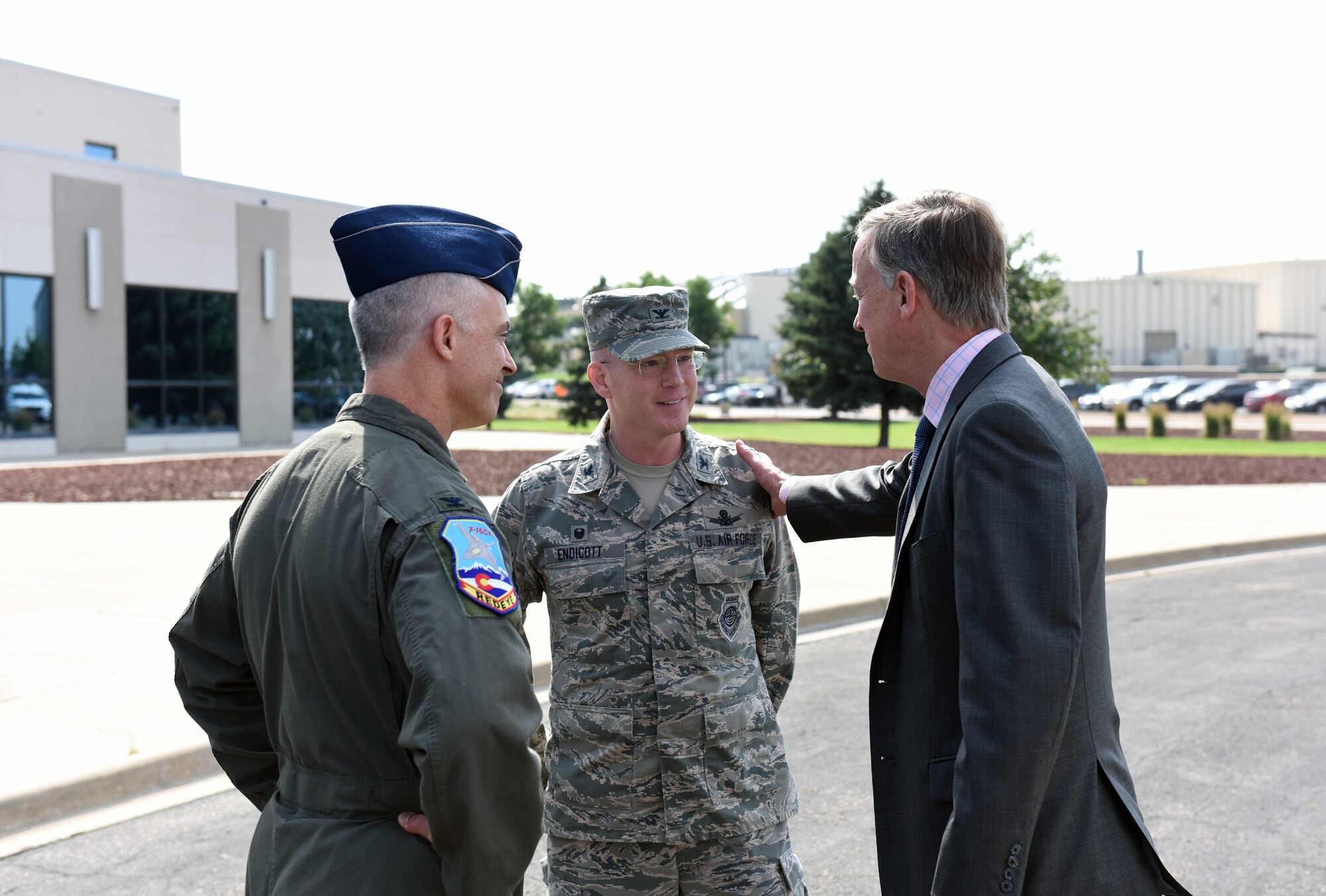 Gov. John Hickenlooper of Colorado, bids farewell to Col. Troy Endicott, center, 460th Space Wing commander, and Col. Brian Turner, far left, 140th Wing commander, following a visit at Buckley Air Force Base, Colorado, July 17, 2018.