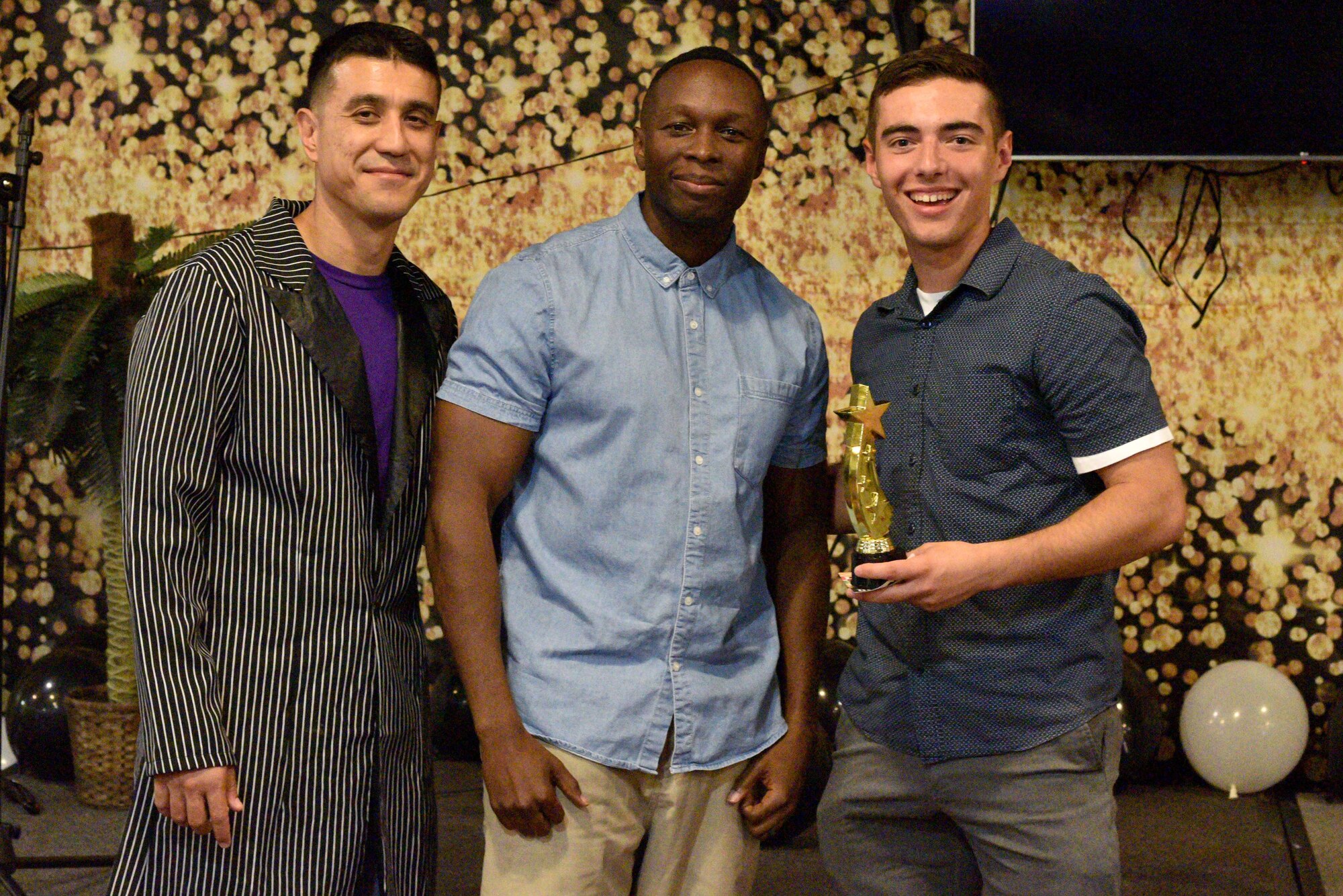 U.S. Air Force Col. Ricky Mills, 17th Training Wing commander and Chief Master Sgt. Lavor Kirkpatrick, 17th TRW command chief, present Airman 1st Class Dylan Hunter, 316th Training Squadron student, an award for the semi-annual Goodfellow’s Got Talent show at the Crossroads Student Ministry Center on Goodfellow Air Force Base, Texas, July 13, 2018. Hunter won third place for his performance. (U.S. Air Force photo by Senior Airman Randall Moose/Released)
