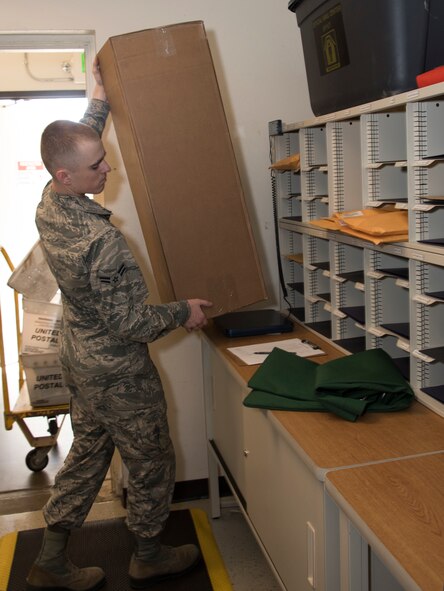 Airman 1st Class Noah Carlton, 60th Force Support Squadron, weighs a package, May 5, 2018, Travis Air Force Base, Calif. The 60 FSS Official Mail Center is responsible for processing mail for Travis AFB, David Grant USAF Medical Center, and commercial company deliveries. (U.S. Air Force Photo by Heide Couch)