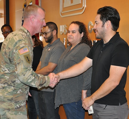 Col. Kirk Gibbs, U.S. Army Corps of Engineers Los Angeles commander, presents Barron Arakawa, Emergency Management specialist, with a commander’s coin for his participation in Bring a Child to Work Day April 26 at the District headquarters.