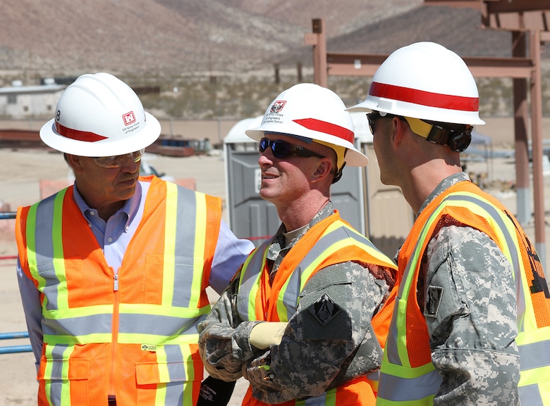 Col. Kirk Gibbs, U.S. Army Corps of Engineers Los Angeles District commander, center, speaks with other Corps employees while touring several project sites during a Sept. 9 to 10, 2015, visit to the National Training Center at Fort Irwin, California.