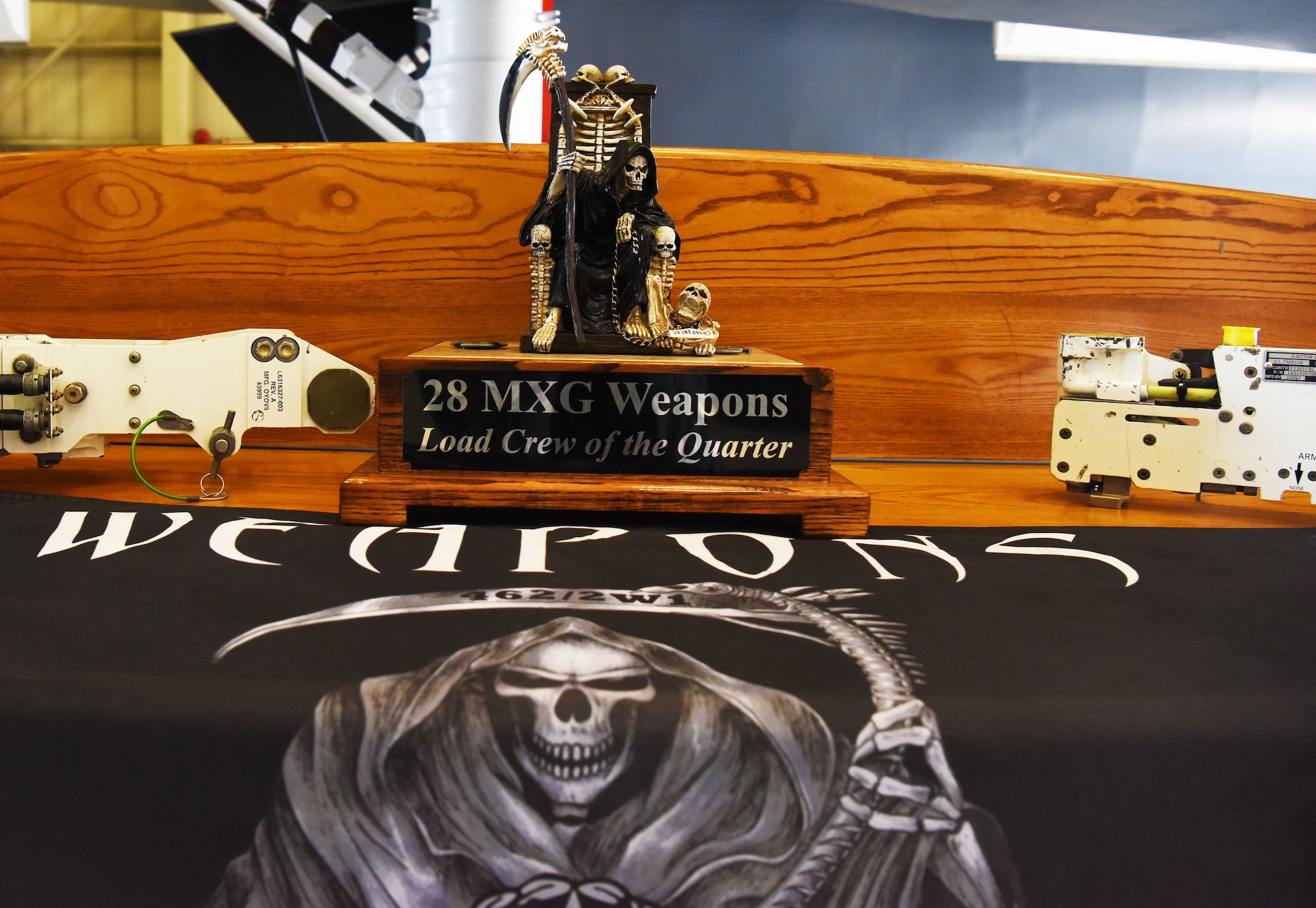 The trophy for the 28th Maintenance Group Weapons load crew of the quarter is displayed at the Load Crew Training Facility at Ellsworth Air Force Base, S.D., July 13, 2018. Two teams of four from the 34th and 37th Aircraft Maintenance Units competed to see who could load three 500-pound bombs on a simulated B-1 Bomber the fastest with the least amount of errors. (U.S Air Force photo by Airman 1st Class Thomas Karol)