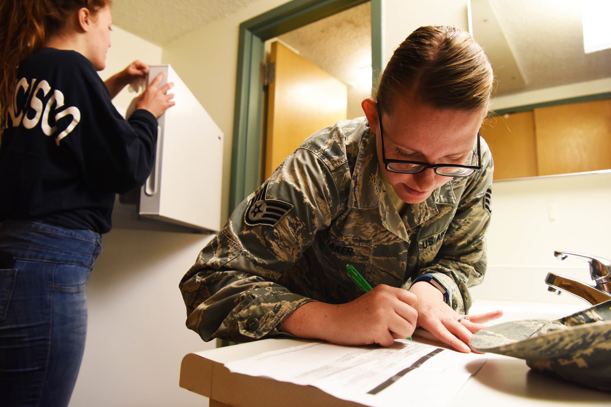 Staff Sgt. Hailey Staker, an Airman dorm leader, completes a checklist at Ellsworth Air Force Base, S.D., July 17, 2018. Dorm leaders verify all processing paperwork and ensure Airman clean their rooms before new residents move in. (U.S. Air Force photo by Airman 1st Class Thomas Karol)