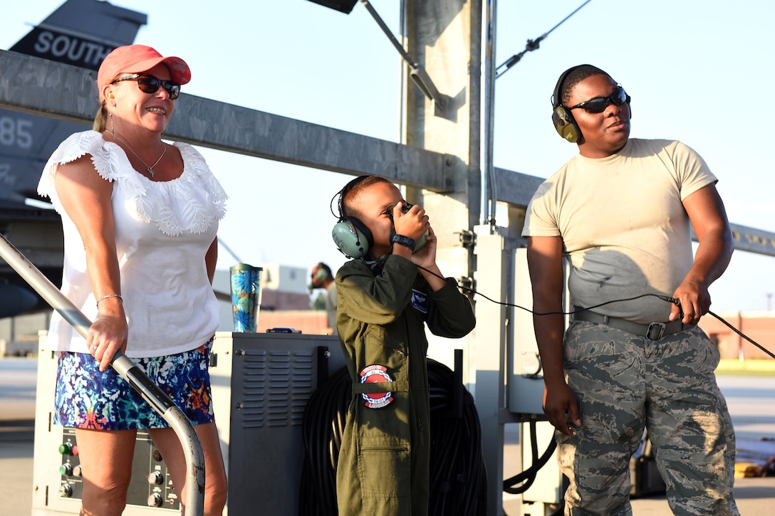 Air Force family members watch a pilot take off.