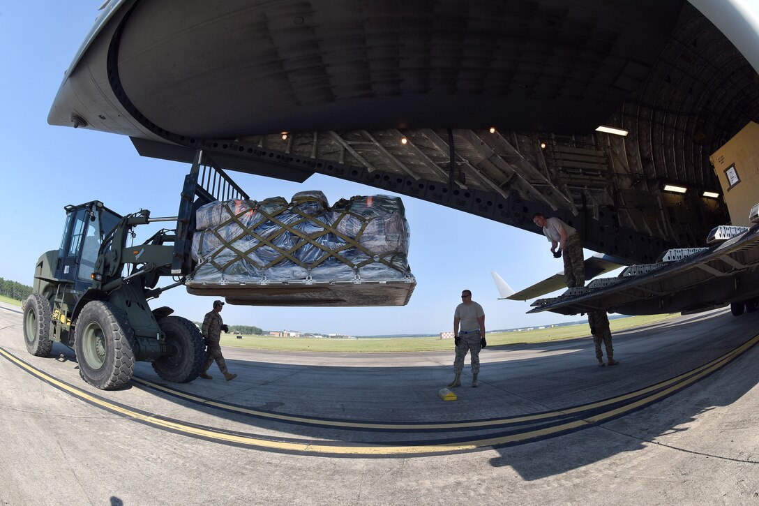 Airmen use a forklift to load cargo onto a C-17 Globemaster III.