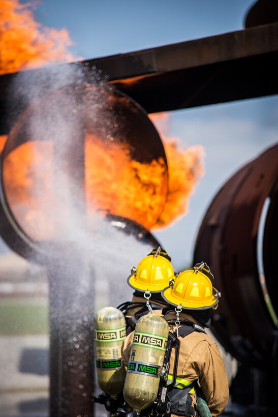 Firefighters and civilians battle a simulated fire as a team.