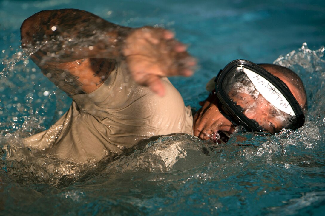 Airman swims wearing goggles.