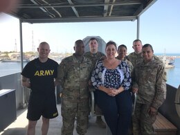 Theresa Scott, family readiness support assistant, 1st Theater Sustainment Command (TSC), middle, poses with several 1st TSC Soldiers while onboard an Army Landing Support Vessel, June 16. Scott traveled to Camp Arifjan to experience life as a Soldier on deployment.