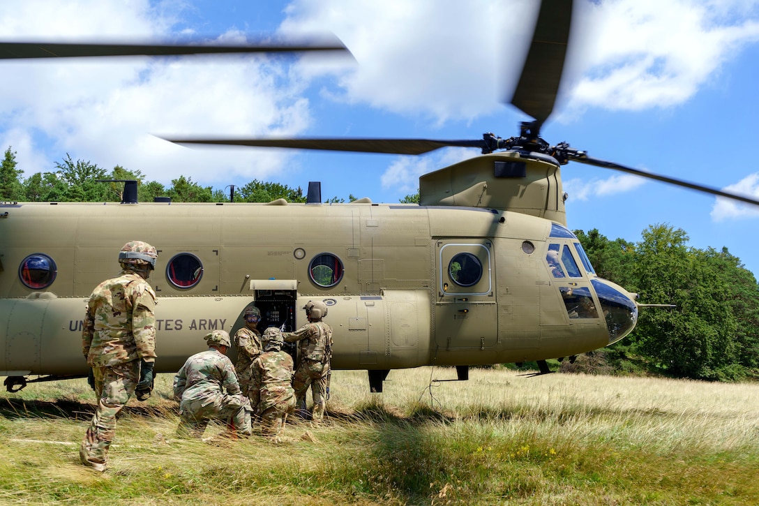 Soldiers refuel a CH-47 Chinook helicopter.