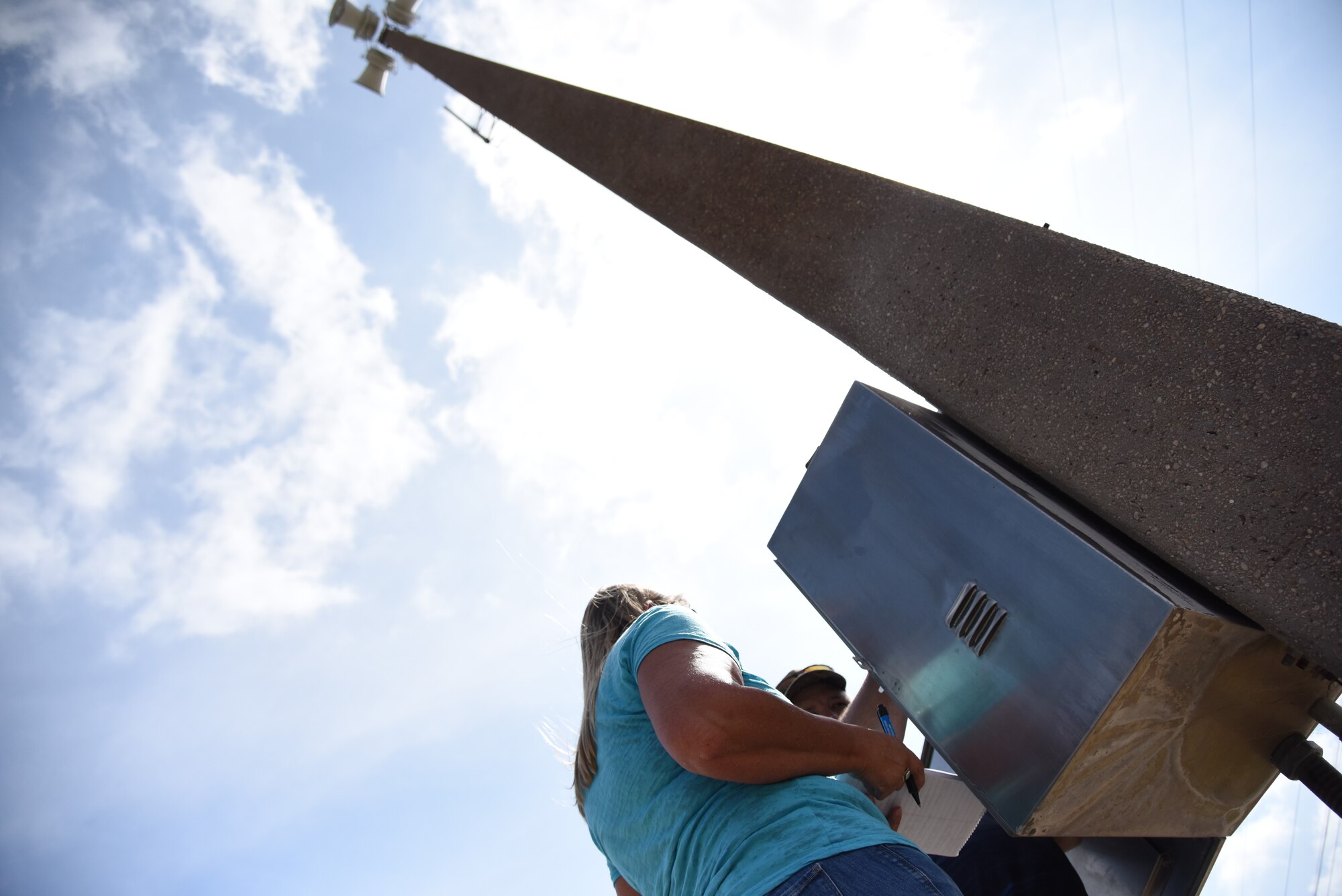 Skip Thomas, communication contractor, and Sharon Macy, 47th Communications Squadron installation Radio Frequency transmission systems manager, work on one of 16 poles connected to the giant voice system at Laughlin Air Force Base, Texas, on June 29, 2018. Laughlin’s system, which comprises of 16 35-foot concrete poles, with four speakers individually pushing 400 watts of audio each, notifies base personnel of emergency situations, as well as marks the official start and finish of a duty day.  (U.S. Air Force photo by 1st Lt. Mickel McGann)