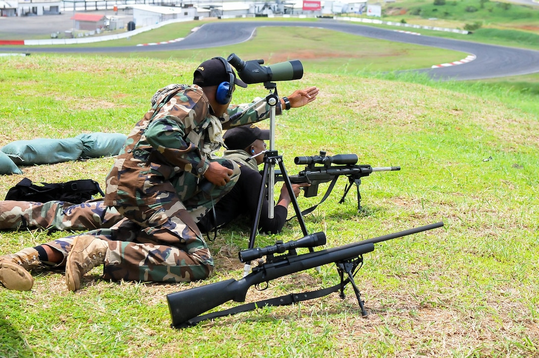 An observer of team Dominican Republic locates targets in the unknown distance shooting competition