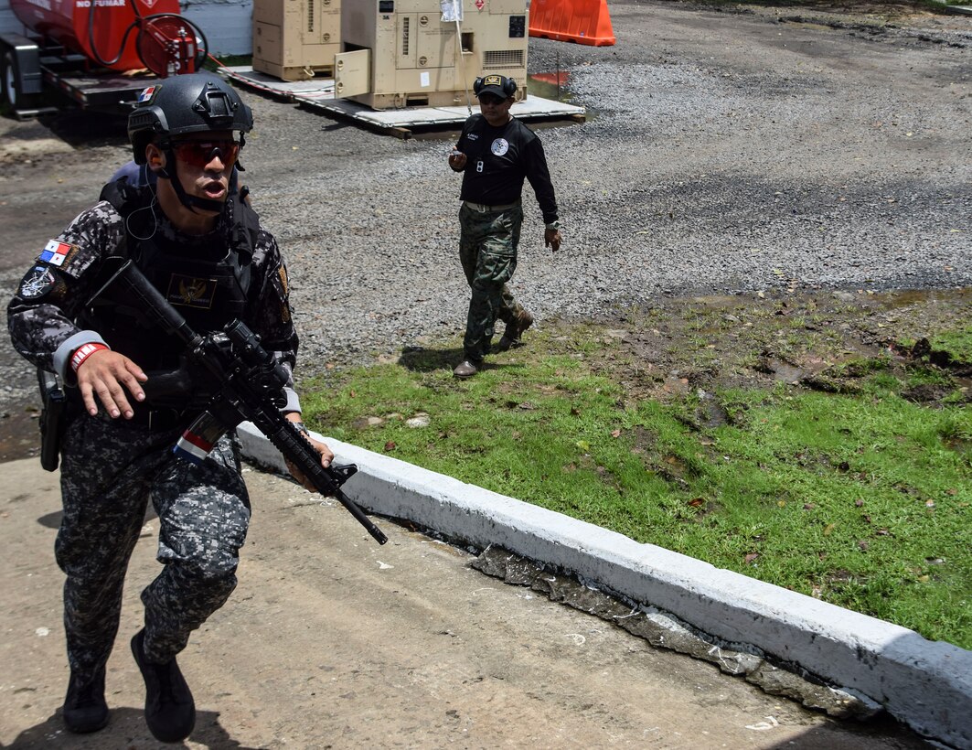 A Panamanian comando runs to assault the range as part of Fuerzas Comando
