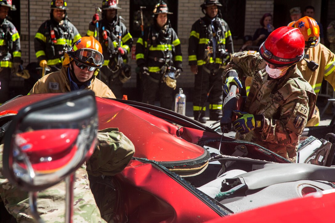 Soldiers use the “Jaws of Life” tool to remove a simulated casualty from a vehicle.