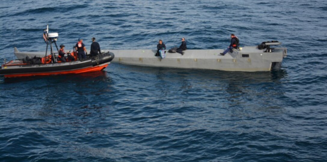 A Coast Guard Cutter Alert boarding team prepares to remove contraband from a suspected low-profile go-fast vessel in international waters