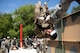 An airman navigates along a rope while upside-down during an obstacle course.