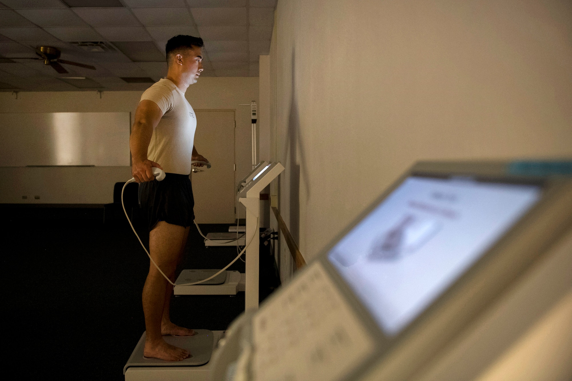 An airman undergoes a body composition measurement test.