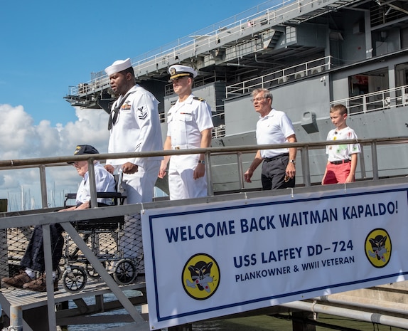 Petty Officer 2nd Class Clinton Leonard, second to left, a hospital corpsman serving at Naval Health Clinic Charleston, ushers WWII Veteran Waitman Kapaldo, left, across the brow to the USS Laffey July 6, 2018, at Patriots Point in Mount Pleasant, S.C., as Kapaldo visited the destroyer for the first time in 73 years. Kapaldo is a member of the Laffey’s original 1944 crew.
